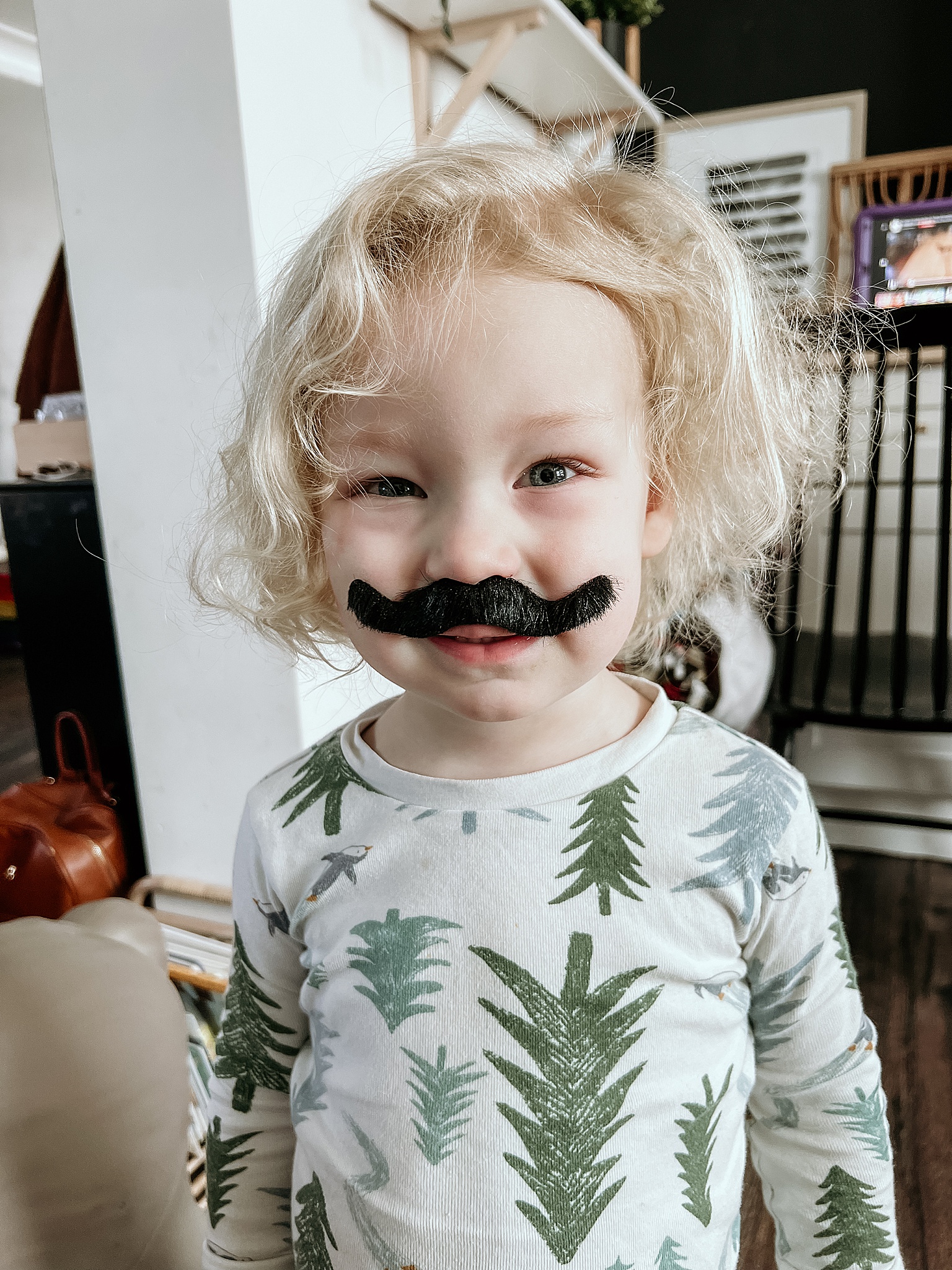 young toddler wearing fake mustache