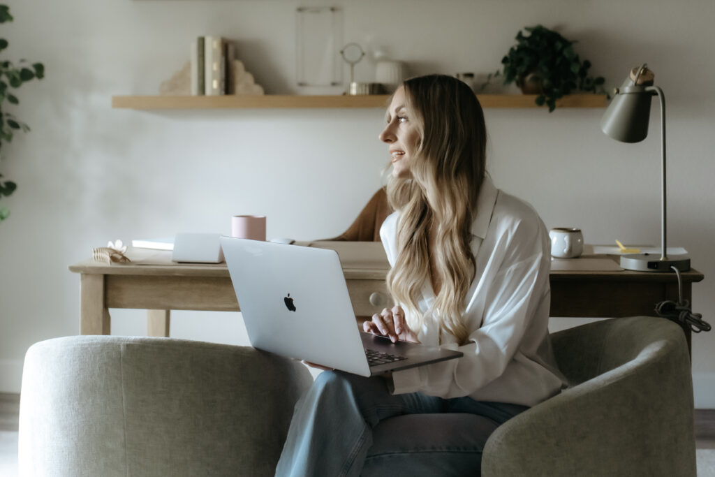  A bright, airy desk scene with an open laptop and coffee in soft summer light — quiet, intentional, not chaotic.